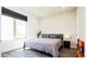 Sunlit bedroom features a large window, gray bedding, and hardwood floors at 1323 Elati St # 3, Denver, CO 80204