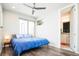 This bedroom features a ceiling fan, modern art, wood floors, and an ensuite bathroom at 1323 Elati St # 3, Denver, CO 80204