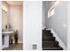 Hallway with powder room featuring a sink and a dark-wood staircase with white risers and trim at 1323 Elati St # 3, Denver, CO 80204