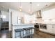 Bright kitchen with stainless steel appliances, island with seating and modern pendant lighting at 1323 Elati St # 3, Denver, CO 80204