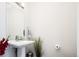 Minimalist powder room with a pedestal sink, rectangular mirror, and decorative greenery at 1323 Elati St # 3, Denver, CO 80204