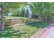 Green backyard with a wooden fence and mature trees creating a private outdoor space at 2312 Dogwood Dr, Erie, CO 80516