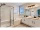 Bathroom featuring a large soaking tub, glass-enclosed shower, and double vanity with modern fixtures at 2312 Dogwood Dr, Erie, CO 80516