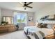 Bright bedroom featuring a ceiling fan, dresser with mirror and a window with ample sunlight at 2312 Dogwood Dr, Erie, CO 80516