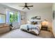 Bright bedroom featuring a ceiling fan, dresser with mirror and a window with ample sunlight at 2312 Dogwood Dr, Erie, CO 80516