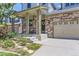 Inviting covered front porch with stone pillars and a well-manicured garden and stone walkway at 2312 Dogwood Dr, Erie, CO 80516