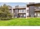 Multi-level townhouse featuring a grassy lawn, private balconies, and outdoor seating at 6515 Pinewood Dr, Parker, CO 80134