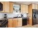 Bright kitchen with stainless steel appliances, black dishwasher, white tile backsplash, and granite countertops at 6515 Pinewood Dr, Parker, CO 80134