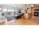 Open-concept living room with hardwood floors, a leather sofa, and access to a balcony at 6515 Pinewood Dr, Parker, CO 80134