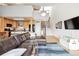 Open-concept living room with kitchen, staircase, leather sofa, and modern furnishings at 6515 Pinewood Dr, Parker, CO 80134