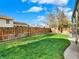 Lush green backyard featuring a neatly fenced yard and mature tree providing shade at 13935 E Idaho Pl, Aurora, CO 80012