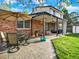 Spacious backyard with a brick house, table and chairs under a patio, and well-maintained lawn at 13935 E Idaho Pl, Aurora, CO 80012