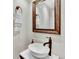 Stylish powder room featuring a vessel sink, modern faucet, and a decorative mirror at 13935 E Idaho Pl, Aurora, CO 80012