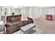 Cozy living room with comfortable brown couch, neutral decor, and a dining area at 13935 E Idaho Pl, Aurora, CO 80012
