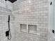 Modern shower design with sleek subway tile and mosaic-tiled niche shelves at 13935 E Idaho Pl, Aurora, CO 80012