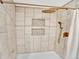 Elegant tiled shower featuring a rainfall shower head and built-in niche shelves at 13935 E Idaho Pl, Aurora, CO 80012