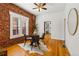 Dining area with exposed brick, round glass table, and modern chairs at 279 Delaware St, Denver, CO 80223