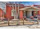 Red brick home featuring a cozy covered porch and a neatly fenced front yard at 279 Delaware St, Denver, CO 80223