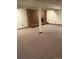 Spacious finished basement featuring a cozy brick fireplace and neutral carpeting at 8542 W 10Th W Ave, Lakewood, CO 80215