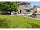 Exterior of the home featuring backyard with outdoor kitchen, deck, hot tub, and well-maintained lawn at 3540 Brushwood Dr, Castle Rock, CO 80109