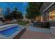 Backyard with a hot tub, lawn, patio area, and mature trees, perfect for outdoor living at 3540 Brushwood Dr, Castle Rock, CO 80109