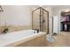 Well-lit bathroom featuring a soaking tub, glass enclosed shower, and access to a walk-in closet at 3540 Brushwood Dr, Castle Rock, CO 80109