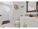 Bathroom with mosaic backsplash, white cabinetry, and a view to the laundry room at 3540 Brushwood Dr, Castle Rock, CO 80109