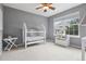 Cozy Bedroom with a white crib, side table, ceiling fan, and window offering natural light at 3540 Brushwood Dr, Castle Rock, CO 80109