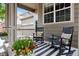 Cozy front porch with rocking chairs, colorful pillows, and a striped rug at 3540 Brushwood Dr, Castle Rock, CO 80109