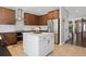 Open concept kitchen with stainless appliances, center island, dark wood cabinets and tile floors at 3540 Brushwood Dr, Castle Rock, CO 80109