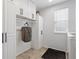 Well-lit laundry room featuring ample storage, white cabinetry, and wood look floors at 3540 Brushwood Dr, Castle Rock, CO 80109