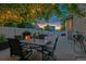 Outdoor patio with a fire pit, dining table, and string lights creating a cozy ambiance at 3540 Brushwood Dr, Castle Rock, CO 80109