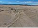 Expansive aerial view captures the home, accompanying buildings, and dirt road access at 11810 Mesa View Rd, Larkspur, CO 80118