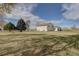 Wide open backyard with mature trees and sprawling lawn, providing room for recreation at 11810 Mesa View Rd, Larkspur, CO 80118