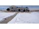 Backyard of home with patio, sliding doors, and snow covered ground at 11810 Mesa View Rd, Larkspur, CO 80118
