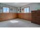 Carpeted basement area with natural lighting with wood paneled walls and accent wallpaper at 11810 Mesa View Rd, Larkspur, CO 80118