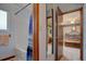 Bathroom featuring a tub/shower combo with blue curtain, mirror, and doorway to bedroom at 11810 Mesa View Rd, Larkspur, CO 80118
