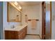 Bathroom with a double sink vanity, light fixtures, and neutral wallpaper at 11810 Mesa View Rd, Larkspur, CO 80118
