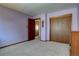 Neutral carpeted bedroom features closet, and entry doors with light lavender walls at 11810 Mesa View Rd, Larkspur, CO 80118