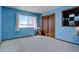 Bright blue bedroom featuring carpet, closet, and a window with outdoor views at 11810 Mesa View Rd, Larkspur, CO 80118