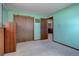 Green carpeted bedroom with closet space, and views through the entry way at 11810 Mesa View Rd, Larkspur, CO 80118