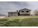 Two-story home has stone and neutral siding with a well maintained lawn at 11810 Mesa View Rd, Larkspur, CO 80118