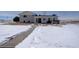 Backyard view showcasing a walkway, outdoor patio with hot tub, and snowy landscape at 11810 Mesa View Rd, Larkspur, CO 80118