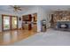 Open-concept living room with stone fireplace, hardwood floors, and natural light at 11810 Mesa View Rd, Larkspur, CO 80118