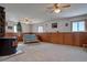 A large carpeted living room with wood paneled walls and a cozy seating area around an electric fireplace at 11810 Mesa View Rd, Larkspur, CO 80118