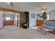 Carpeted living room features a stone fireplace, wood trim and a comfortable seating area at 11810 Mesa View Rd, Larkspur, CO 80118