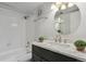 Bathroom featuring a black vanity, marble countertop, and a white tiled shower and tub at 3051 S Ursula Cir # 302, Aurora, CO 80014