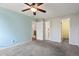 Spacious bedroom featuring a ceiling fan, grey carpet, and a calming blue accent wall at 3051 S Ursula Cir # 302, Aurora, CO 80014