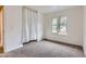 A sunlit bedroom with neutral walls, carpeting, curtains, and view to the outdoors through double windows at 8759 E Roundtree Ave, Greenwood Village, CO 80111