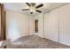 A bright bedroom with ceiling fan, neutral walls, carpeting and closet doors and view to the hallway at 8759 E Roundtree Ave, Greenwood Village, CO 80111